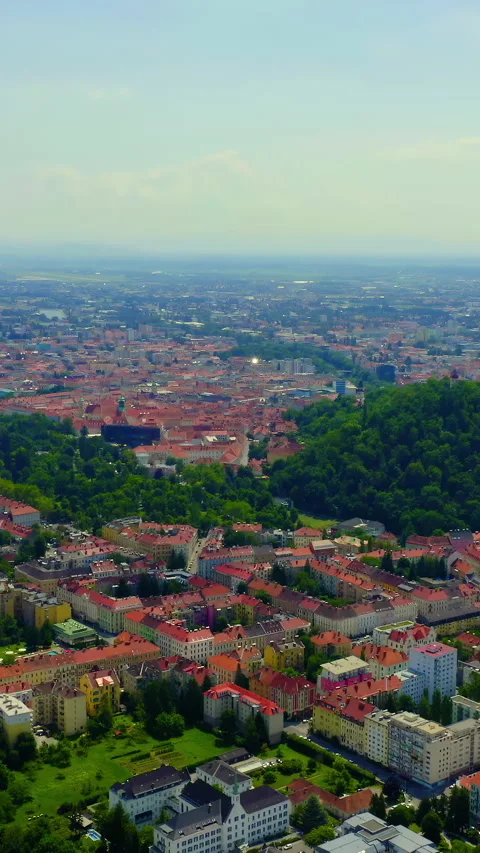 Vertical video. Graz, Austria. Mount Schlossberg rising above the historic city Stock Footage 333620845
