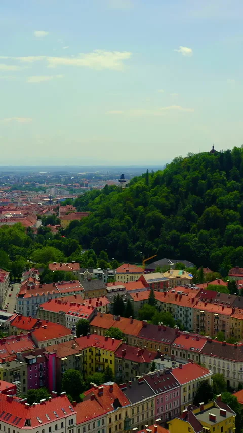 Vertical video. Graz, Austria. Mount Schlossberg rising above the historic city Stock Footage 334780424