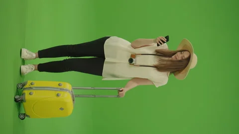 Vertical Video. Green Screen. Chroma Key. Woman Standing With a Hat and Luggage Video stock 220748765