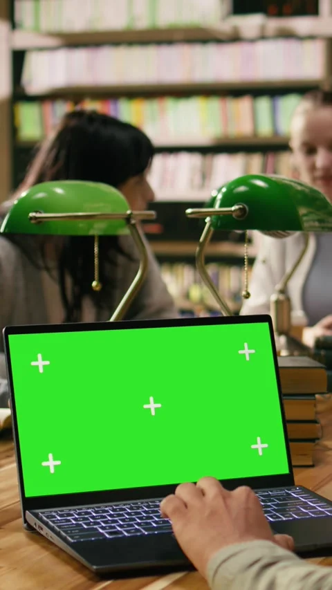 Vertical Video Green screen chroma key on laptop in front of study group at Stock Footage 336379732