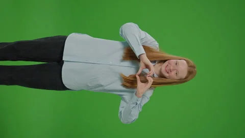 Vertical Video Green Screen. Delightful Girl Forms A Heart With Her Hands Stock Footage 264188467