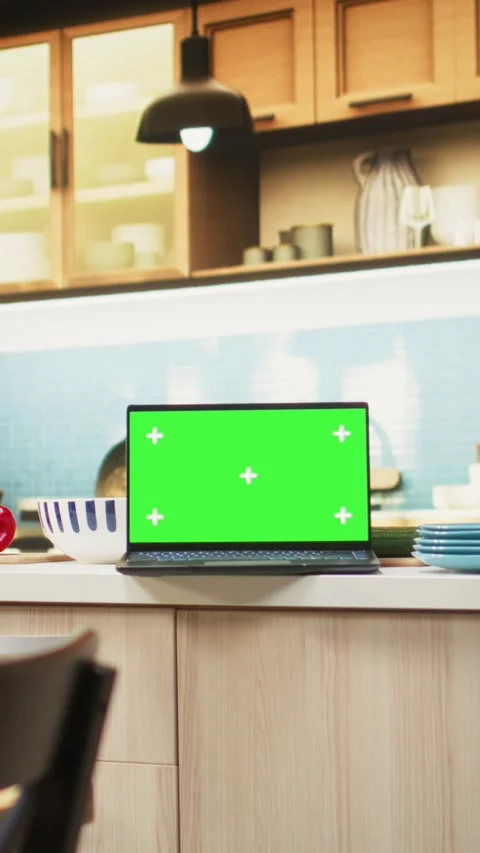 Vertical Video Green screen on laptop in modern home kitchen with cupboards and Stock Footage 321375707