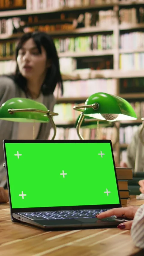 Vertical Video Green screen mockup on laptop inside university library desk Stock Footage 336379792