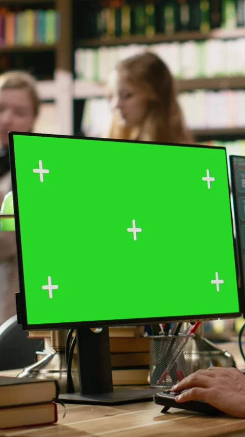Vertical Video Green screen mockup on computer monitor at wooden library table Stock Footage 337530768
