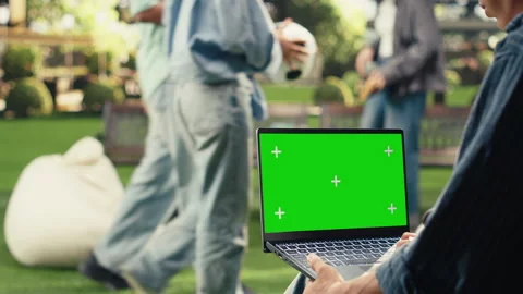 Vertical Video Green screen mockup sitting on bench with laptop as student works Stock Footage 340800195