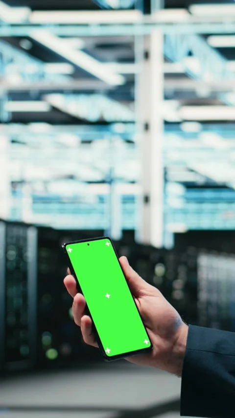 Vertical video Green screen smartphone used by data center admin managing Stock Footage 329943661