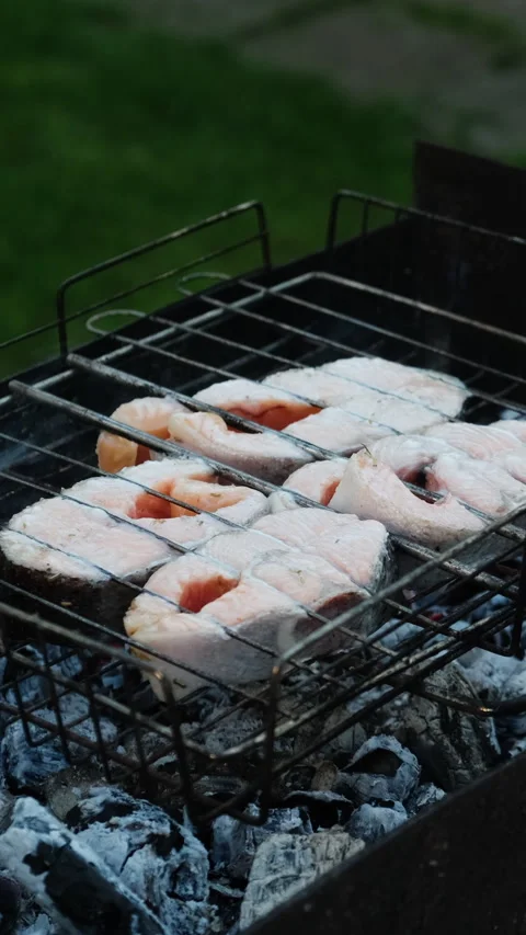Vertical video. Grilling steaks of salmon fish in backyard during summer we.. Stock Footage 340333697