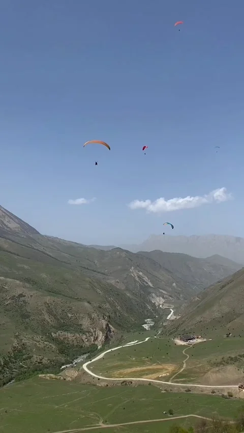 Vertical video with a group of paragliders flying over the rocks. Kabardino Stock Footage 275476190