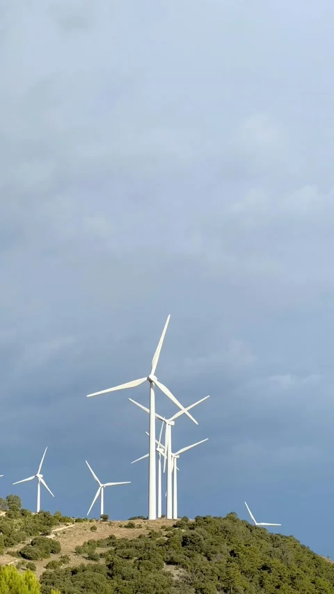 Vertical video of a group of windmills on top of a hill with a dramatic electric Stock Footage 205884027