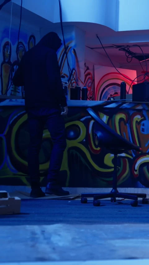 Vertical video Hacker arriving in underground base, looking at spray cans Stock Footage 319560368