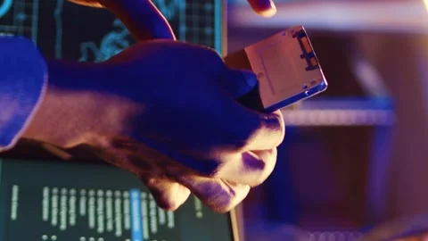 Vertical video Hacker holding SSD with computer exploit Stock Footage 255251486