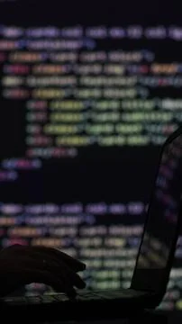 Vertical video. Hacker writing code cracking computer. Programming code in the Stock Photos