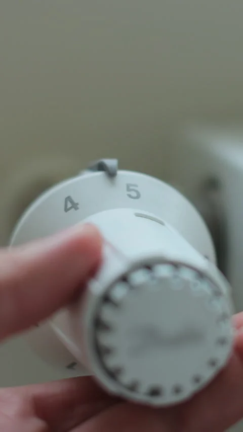 Vertical video Hand adjusting temperature on heating radiator thermostat. Stock Footage 339061002