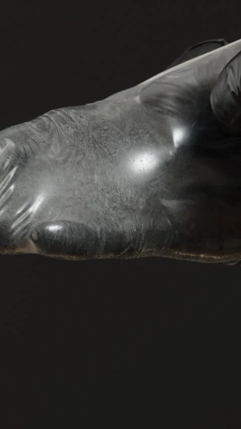 Vertical video. A Hand in Black Gloves Pulling a Condom Over the Entire Hand, Stock Footage 301085644