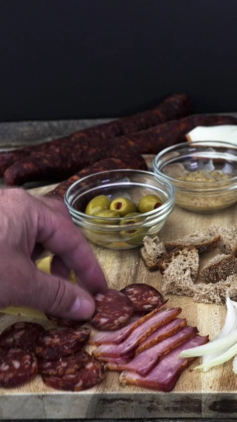 Vertical video from hand in blued motion taking sausage slice and bread slice 스톡 동영상 324836721