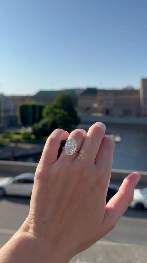 Vertical video of hand with diamond wedding band above urban water Stock Footage 317335590