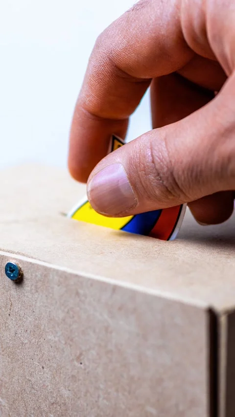 Vertical video of hand inserting a colorful Colombian flag into a cardboard.. 動画素材 335967080