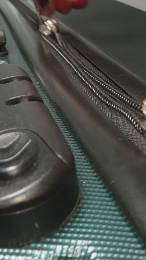 Vertical video. A Hand inserts the zipper pulls into the combination lock and Stock Footage 282296293