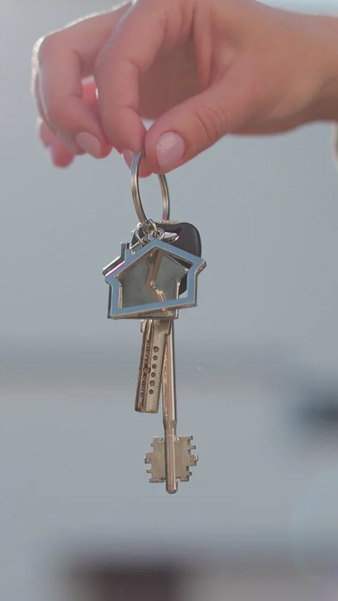 Vertical video A hand with a keychain in the shape of a small house and keys Stock Footage 338088489