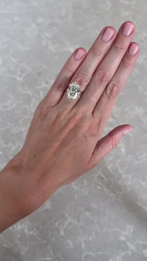 Vertical video hand movement with oval diamond ring on gray marble background Stock Footage 316813730
