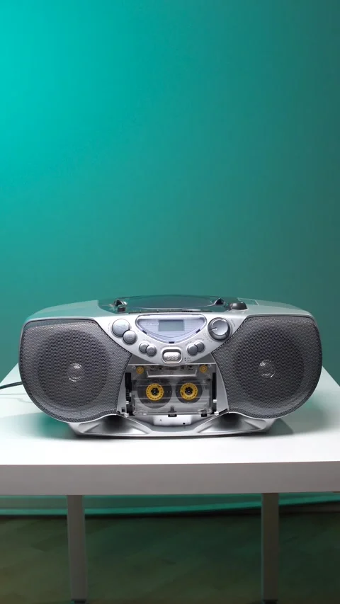 Vertical video hand operating a silver boombox, pressing the play button to Stock Footage 345530554