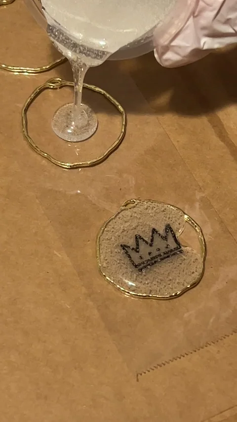 Vertical video of hand pouring epoxy resin into open bezel making jewelry Stock Footage 221381919