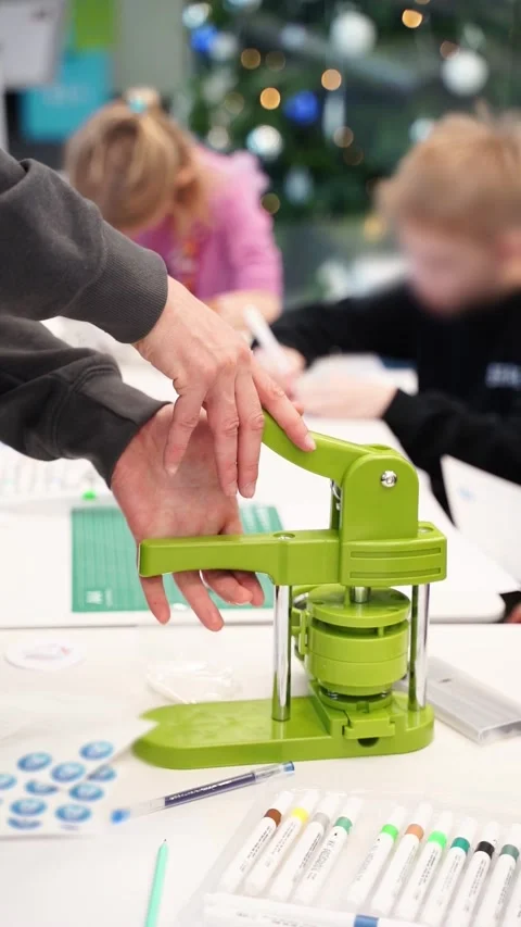 Vertical video of Hand pressing machine in action, creating custom badge Stock Footage 322975870
