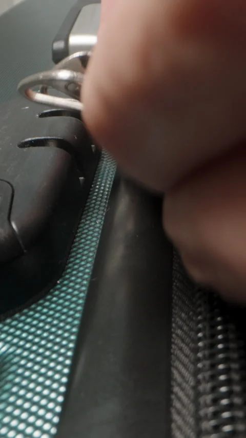 Vertical video. A Hand pulls the zipper closed on the suitcase, securing the Stock Footage 282294426