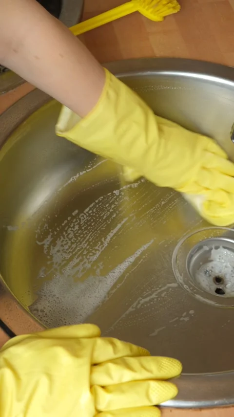 Vertical video of hand in rubber glove wiping kitchen sink with sponge cloth Stock Footage 336615308