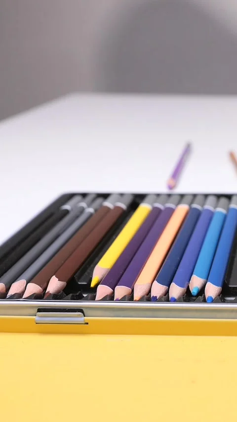 Vertical video hand selecting a brown pencil from an open metal case filled with Stock-Footage 322908734