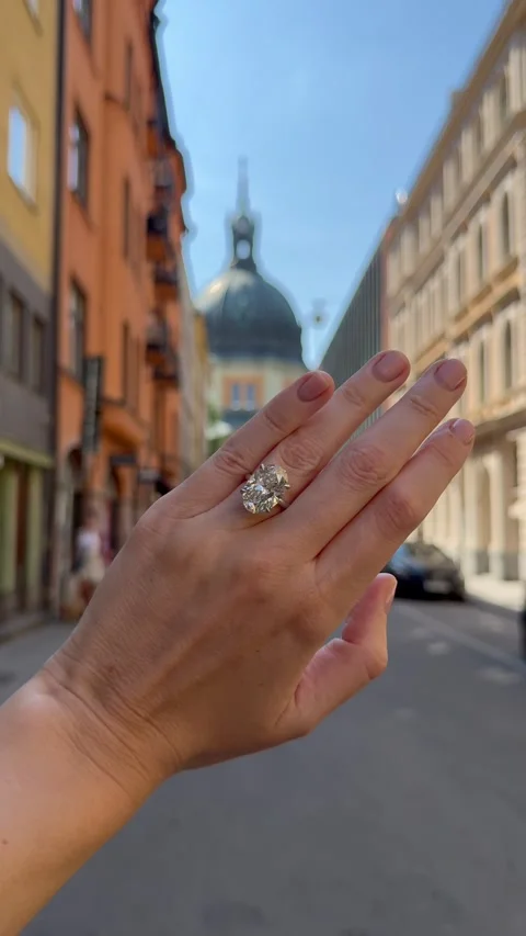 Vertical video of a hand toward the skyline showing an oval diamond ring Stock Footage 317720372