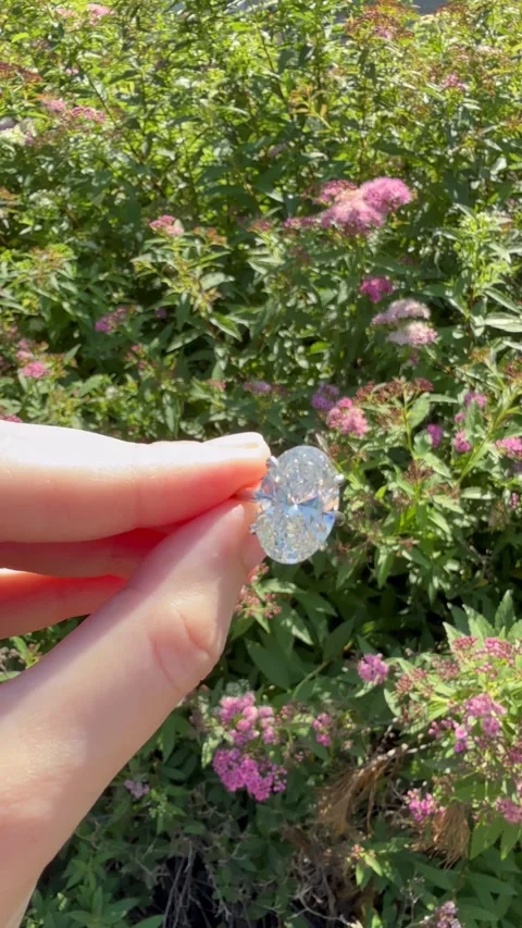 Vertical video, hand turning with oval diamond platinum band engagement ring Stock Footage 317719324
