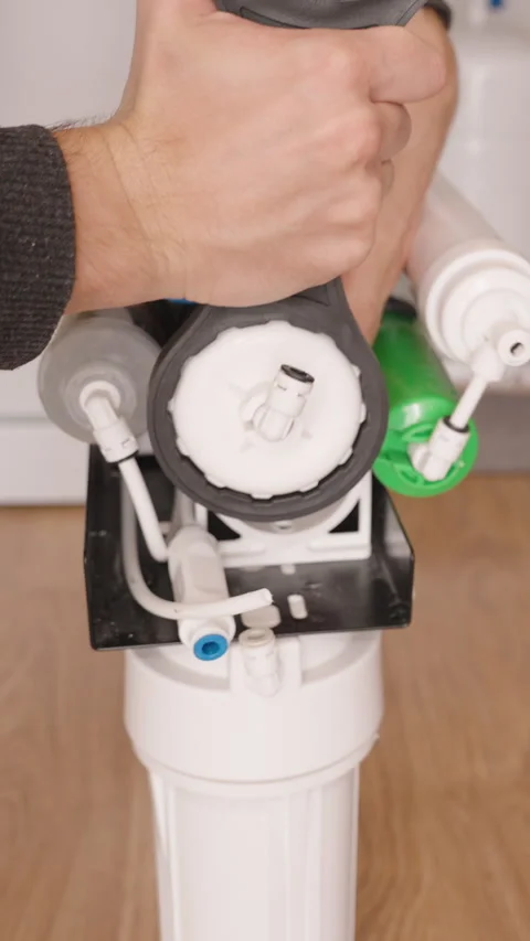 Vertical video. Hand Unscrewing the Lid of a Reverse Osmosis System to Access Stock Footage 296571989