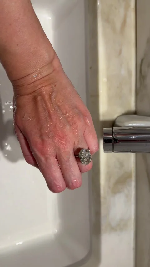 Vertical video hand washing with oval diamond engagement ring sparkle Video stock 317577461