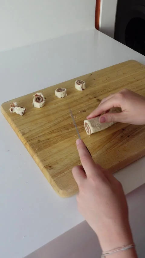 Vertical video of hands cutting rolled slices of filled bread Stock Footage 292404926