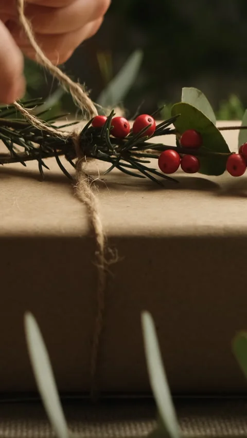 Vertical video. Hands decorating Christmas present with fresh twigs. Stock Footage 252934363