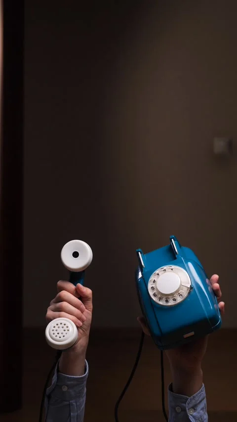 Vertical video hands holding a blue vintage rotary telephone, with one hand 動画素材 323270163