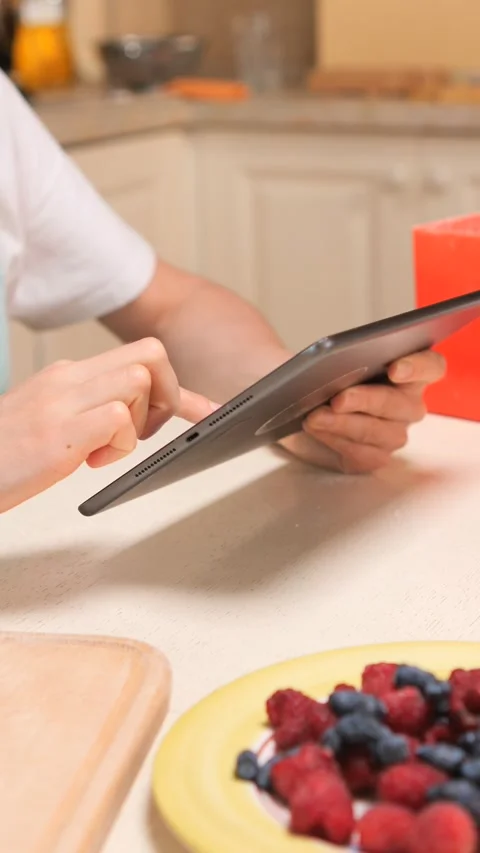 Vertical video hands holding a digital tablet and scrolling on its screen for a Stock Footage 342767014