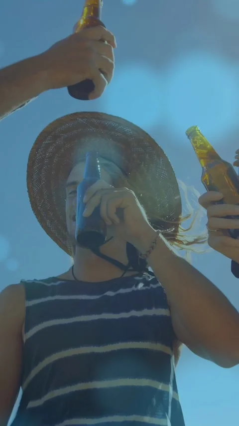Vertical video: Hands raising bottles overhead man reaching up and drinking dark Stock Footage 333977884