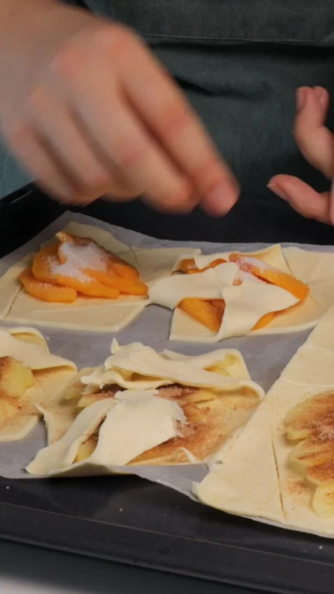 Vertical video. Hands shaping pastry with fruit filling on baking tray, pas.. Stock Footage 320955971