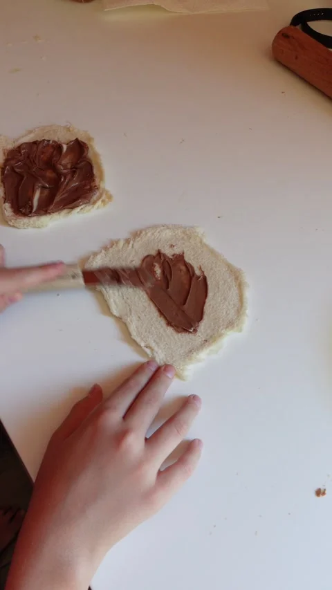 Vertical video of hands spreading chocolate cream on slices of bread Stock Footage 292405127