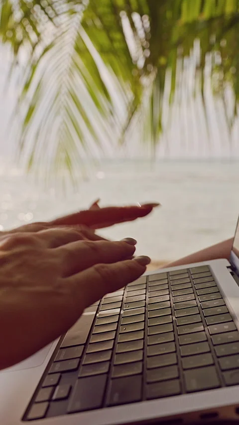 Vertical video. Hands Typing on Laptop Keyboard in Hammock With Palm Leaves Refl Stock Footage 326939751