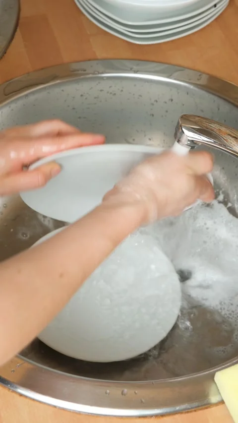 Vertical video of hands washing white ceramic plate with sponge and soap. Stock Footage 337555802