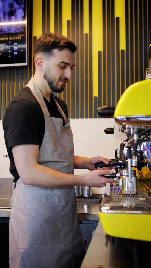 Vertical video of handsome man barista wearing apron is making a cup of tasty Stock Footage 280386565