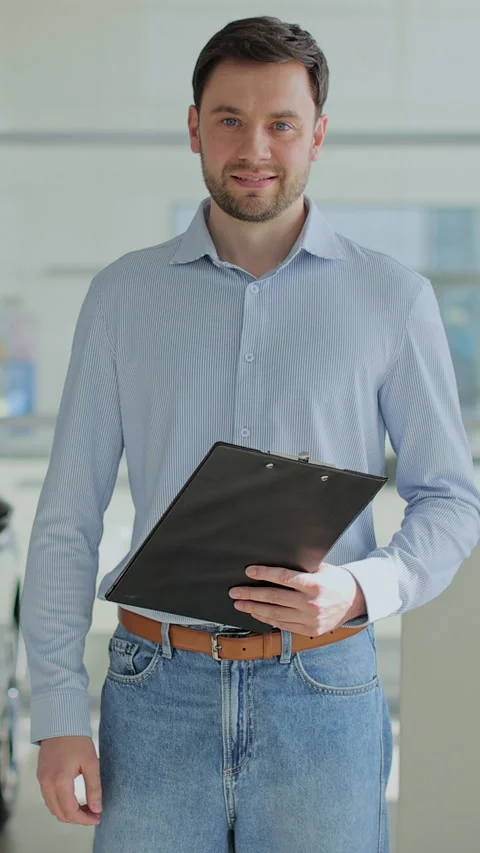 Vertical video Handsome man manager at a car dealership Stock Footage 337239404