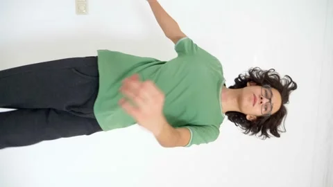 Vertical video. handsome stylish guy with curly hair dancing on a white Stock Footage 147552791