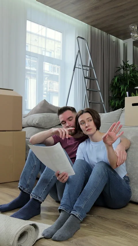 Vertical video. Happy couple sitting and planning new home decoration at home Stock Footage 346201758