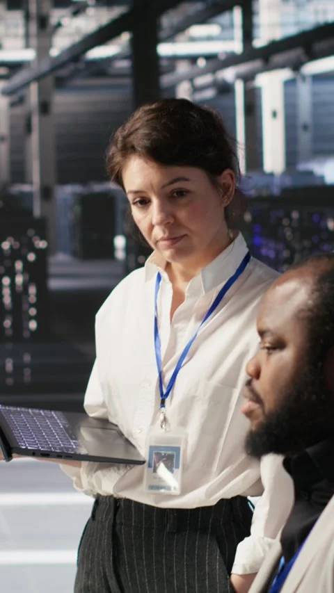 Vertical video Happy data center manager providing positive feedback to engineer Stock Footage 309486418