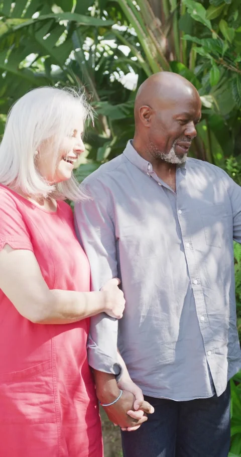 Vertical video of happy diverse senior couple walking in garden arm in arm Stock Footage 346720855