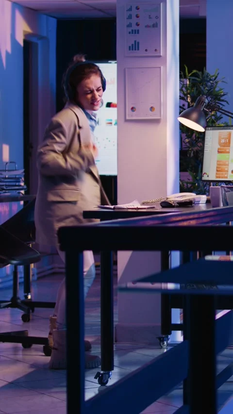 Vertical video: Happy employee analyzing graphs wearing headset Stock Footage 232756530